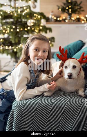 Glückliches Mädchen mit Hund im Wohnzimmer Stockfoto