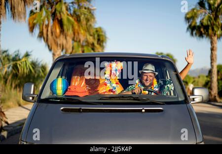 Glücklicher Mann, der mit dem Auto durch das Fenster winkt Stockfoto