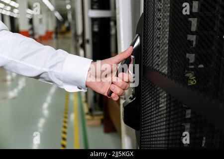 Hände des Geschäftsmannes, der die Tür des Datenservers öffnet Stockfoto