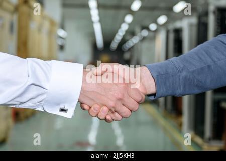 Geschäftsmann schüttelt sich die Hände mit Kollegen in der Fabrik Stockfoto