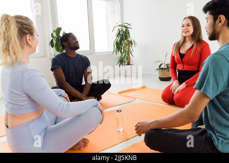 Freunde meditieren und praktizieren Yoga im Übungskurs Stockfoto