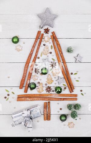 Studioaufnahme von Weihnachtsbaumform aus verschiedenen Gewürzen, Keksen und Weihnachtsschmuck Stockfoto