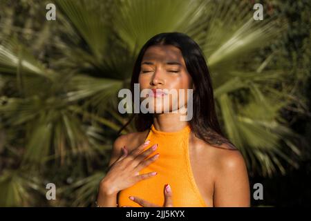 Junge Frau mit geschlossenen Augen Sonnenlicht genießen. Stockfoto