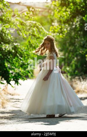 Lächelndes Mädchen trägt Abendkleid auf dem Weg Stockfoto