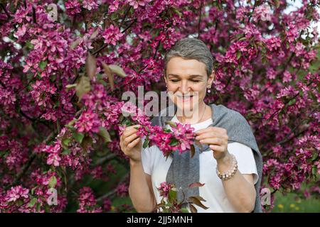 Lächelnde Frau, die den Makamik-Apfelbaum hält Stockfoto