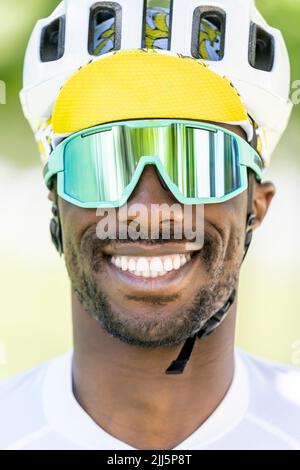 Glücklicher Mann mit Fahrradhelm und Sonnenbrille Stockfoto