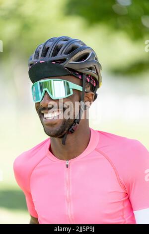 Lächelnder Mann mit Fahrradhelm und Sonnenbrille Stockfoto