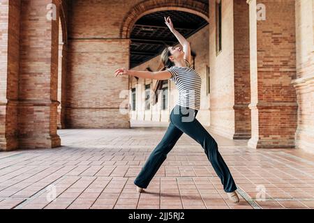 Balletttänzerin, die unter historischen Arkaden tanzt Stockfoto