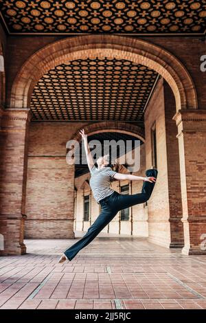 Balletttänzerin, die unter historischen Arkaden tanzt Stockfoto