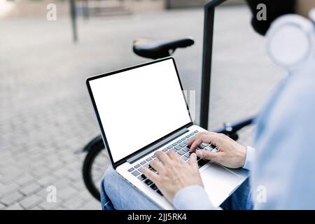 Geschäftsmann tippt auf dem Laptop mit leerem Bildschirm Stockfoto