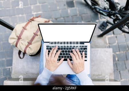 Geschäftsmann, der auf einem Laptop mit leerem Bildschirm arbeitet Stockfoto