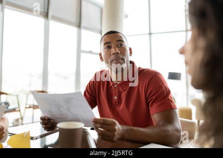Lächelnder Geschäftsmann mit einem Dokument, das eine Geschäftsfrau ansieht Stockfoto