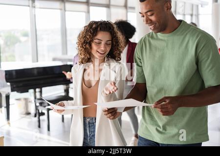 Glückliche Geschäftsfrau über Dokument mit Geschäftsmann diskutieren Stockfoto