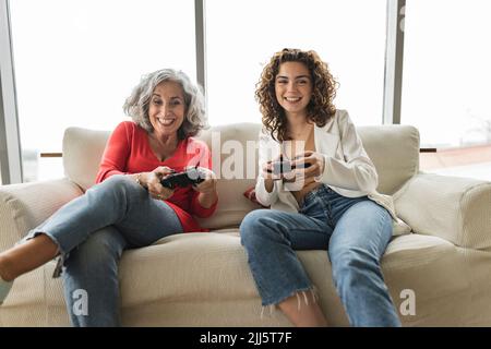 Glückliche Frau mit Freund, der Videospiele spielt Stockfoto