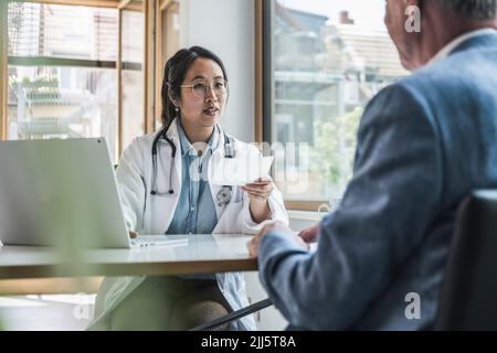 Arzt, der mit dem Patienten über die Verschreibung in der medizinischen Klinik diskutiert Stockfoto