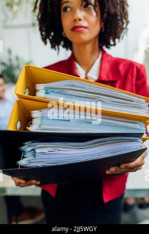 Geschäftsfrau hält Ordner im Büro Stockfoto