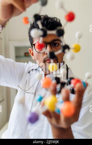 Junge Wissenschaftlerin untersucht Helix-Modell im Labor Stockfoto