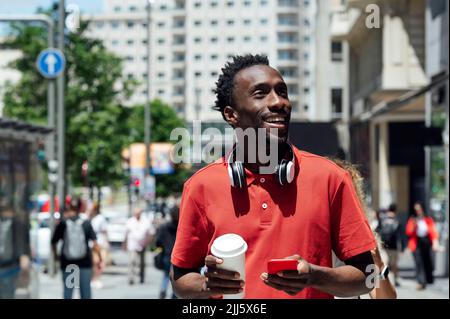 Lächelnder Mann mit Handy und Kaffeetasse Stockfoto