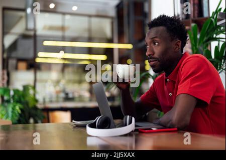 Mann mit Kaffeetasse sitzt im Café Stockfoto
