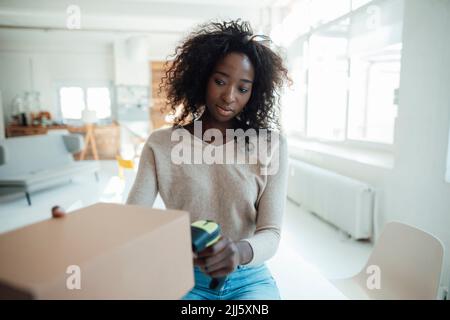 Geschäftsfrau scannt Barcode auf Karton Stockfoto