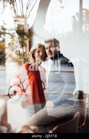 Mann mit Frau im Café durch Glas gesehen Stockfoto