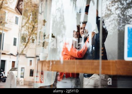 Mann mit Frau nimmt Selfie über Smartphone im Café Stockfoto