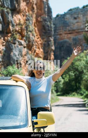 Glückliche Frau mit Arm angehoben Spaß an sonnigen Tag Stockfoto