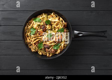 Ein traditionelles italienisches und römisches Gericht, fettuccini Pasta mit Spinat und Pilzen in einer Pfanne. Römische Pasta Stockfoto