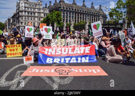 London, England, Großbritannien. 23.. Juli 2022. Demonstranten sitzen und blockieren die Straße auf dem Parliament Square. Demonstranten von Just Stop Oil, Extinction Rebellion, Isolate Britain und anderen Gruppen veranstalteten einen marsch durch das Zentrum Londons, in dem sie die Regierung aufforderten, fossile Brennstoffe zu beenden, große Umweltverschmutzer und Milliardäre zu besteuern, alle Häuser zu isolieren und gegen das Klima und die Lebenshaltungskosten zu handeln. (Bild: © Vuk Valcic/ZUMA Press Wire) Stockfoto