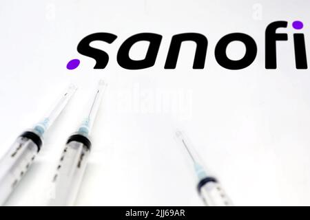 Paris, Frankreich, Juli 2022: Zwei Spritzen auf einer weißen Oberfläche mit dem Sanofi-Logo im Hintergrund. Sanofi ist ein französisches multinationales Pharmaunternehmen und Stockfoto