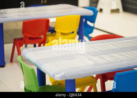 Klassische und farbenfrohe Kindergarten-Klassenzimmer-Stühle. Stockfoto