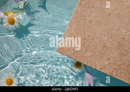 Produktförderung Beauty Kosmetik Schaufenster. Travertin Stein Display mit Blumen im Wasser. Stockfoto