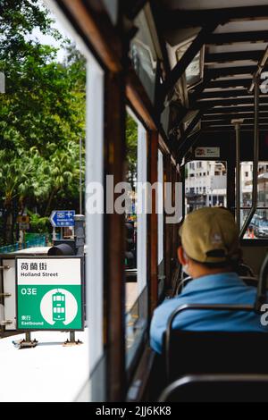 Eine vertikale Aufnahme eines Mannes im zweiten Stock eines Busses in der Holland Street in Hongkong Stockfoto