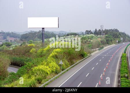 Eine leere Plakatwand mit Kopierfläche auf einem Feld in der Nähe einer Autobahn Stockfoto