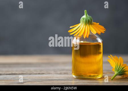 Flasche ätherisches Calendula-Öl oder Infusion und Ringelblumen. Alternative Kräutermedizin. Stockfoto