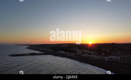 Eine Drohnenaufnahme des Sonnenaufgangs über dem friedlichen Meer und der schlafenden Stadt Stockfoto