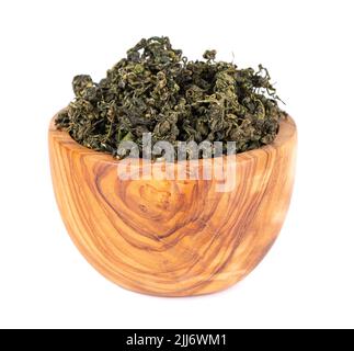 Trockenes gynostemma pentaphyllum-Blatt in einer Olivenschale, isoliert auf weißem schwarzen Grund. Jiaogulan oder Wundergras. Chinesischer Kräutertee Stockfoto