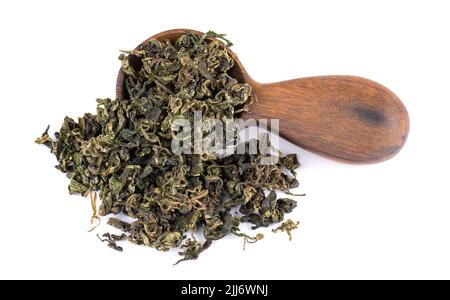 Trockenes gynostemma pentaphyllum Blatt in Holzlöffel, isoliert auf weißem schwarzen Grund. Jiaogulan oder Wundergras. Chinesischer Kräutertee Stockfoto