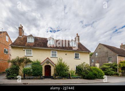 Straßenszene in Fordingbridge, einem kleinen Dorf im New Forest, Hampshire: Hütten am Straßenrand ohne Vorgarten, die sich direkt auf die Straße öffnen Stockfoto