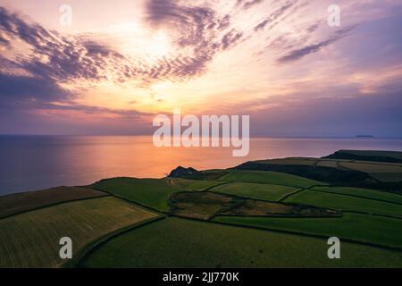 Sonnenuntergang über Feldern und Farmen von Caunter Beach and Cliffs, Hartland Cornwall Heritage Coast, South West Coast Path, Bude, North Cornwall, England Stockfoto