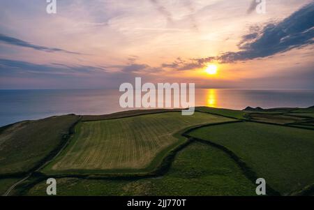 Sonnenuntergang über Feldern und Farmen von Caunter Beach and Cliffs, Hartland Cornwall Heritage Coast, South West Coast Path, Bude, North Cornwall, England Stockfoto