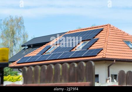 Hausdach mit Photovoltaikmodulen. Historisches Bauernhaus mit modernen Sonnenkollektoren auf Dach und Wand Hochwertiges Foto Stockfoto