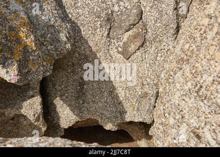 Kleine Spalte oder Schlucht, die durch die Erosion des Meerwassers gebildet wird. Große Felsbrocken oder Sandsteine am Strand oder in den Bergen.Texturdetail von Stockfoto