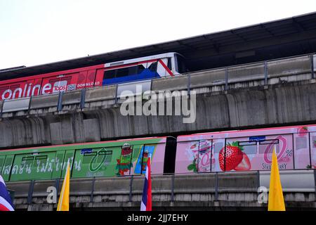 BTS Skytrains, Teil eines erhöhten S-Bahn-Systems in Bangkok, Thailand, und Umgebung, fahren in entgegengesetzte Richtungen auf übereinander liegenden Linien am BTS-Bahnhof Siam in Bangkok, Thailand, Asien. Stockfoto