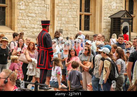 London, Großbritannien. 22.. Juli 2022. Ein Yeoman Warder unterzieht sich mit Besuchern während einer Tour durch den Tower of London. Der Turm, der sich nördlich der Themse befindet, diente als Waffenlager, Schatzkammer, Heimat der Royal Mint und der Kronjuwelen Englands. (Foto von David Mbiyu/SOPA Images/Sipa USA) Quelle: SIPA USA/Alamy Live News Stockfoto