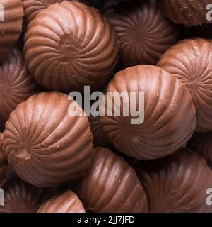 Schokoladenbonbons oder Süßigkeiten, Nahaufnahme von oben, Lebensmittelhintergrund Stockfoto