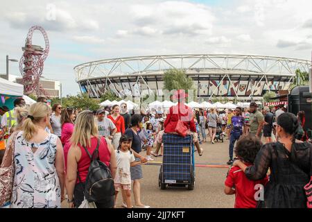 London, Großbritannien. 23.. Juli 2022. Entertainer mischen sich unter die Menschenmassen Lock Busking Gegend des Queen Elizabeth Olympic Park in Stratford. Der zehnte Jahrestag der Londoner Spiele wurde durch das Great Get Together Festival geprägt, das im Queen Elizabeth Olympic Park in Stratford zu einem Sommerfestival stattfand. Der Park wird den ganzen Sommer über von Sonntag, 24. Juli bis Montag, 8. August, ein Festivalgelände beherbergen, das eine Mischung aus Bildschirm- und Bühnenunterhaltung im Norden des Parks bietet. (Foto von David Mbiyu/SOPA Images/Sipa USA) Quelle: SIPA USA/Alamy Live News Stockfoto