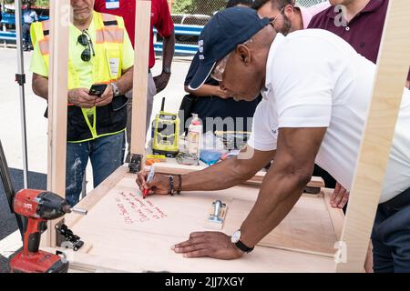 New York, USA. 23.. Juli 2022. Bürgermeister Eric Adams unterzeichnete am 23. Juli 2022 einen klappbaren Tisch während des DVS-Möbelbaus auf dem Campus der JFK High School in New York. Furniture Build-a-Thon wurde vom Fuller Center von Freiwilligen organisiert, um zusammenklappbare Tische und Hocker für ehemals obdachlose Veteranen zu machen, die kürzlich in ihre neuen Häuser gezogen sind. (Foto von Lev Radin/Sipa USA) Quelle: SIPA USA/Alamy Live News Stockfoto