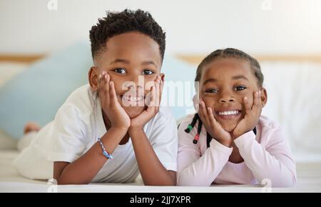 Das größte Geschenk, das unsere Eltern uns gaben, war einander. Ein Bruder und eine Schwester lagen zu Hause im Bett. Stockfoto