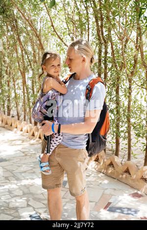 Vater und Kind gehen durch den Tunnel. Menschen, die in den Park gehen. Familienspaziergang zum Zoo. Entdecken Sie gemeinsam Stockfoto